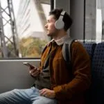 homem de fone no metro ouvindo um audiobook com ajuda do gerador de voz Speechify