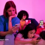 meninas com celulares nas mãos assistindo videos nas redes sociais com algoritmo de interesse